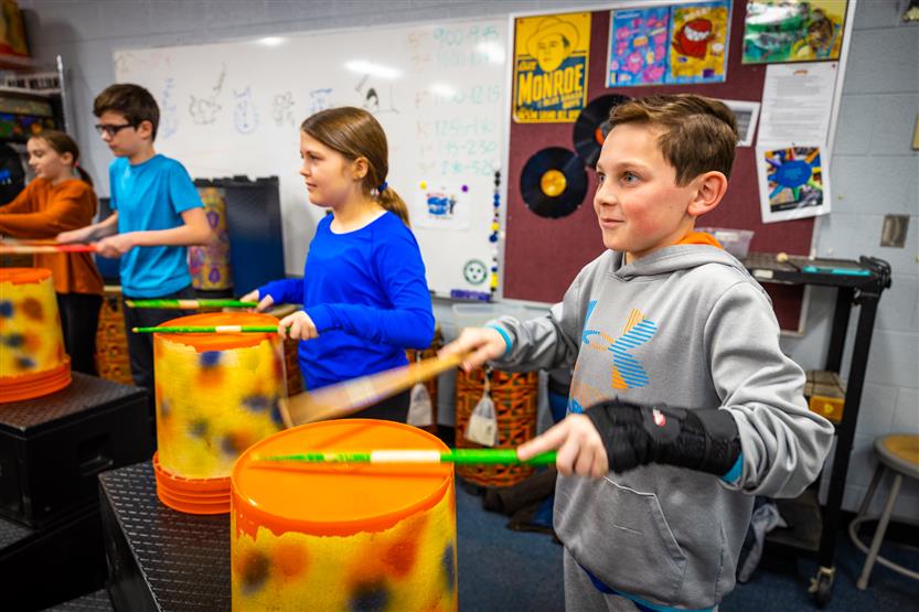 Students play drums in music class